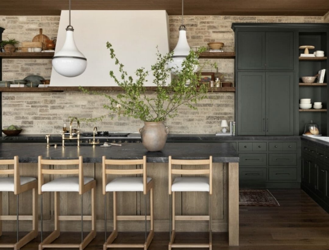 ark cabinets and stained wood island & shelves. The brick walls add texture and is softened with the curved pendants